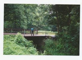 Metgethen, Ort und Bahnstation, Stadtkreis Königsberg Forstweg Metgethen, Forstweg, Brücke über die Moditte, dahinter rechts der ehemalige Friedhof, Blickrichtung nordost Metgethen, Häuser früher und heute